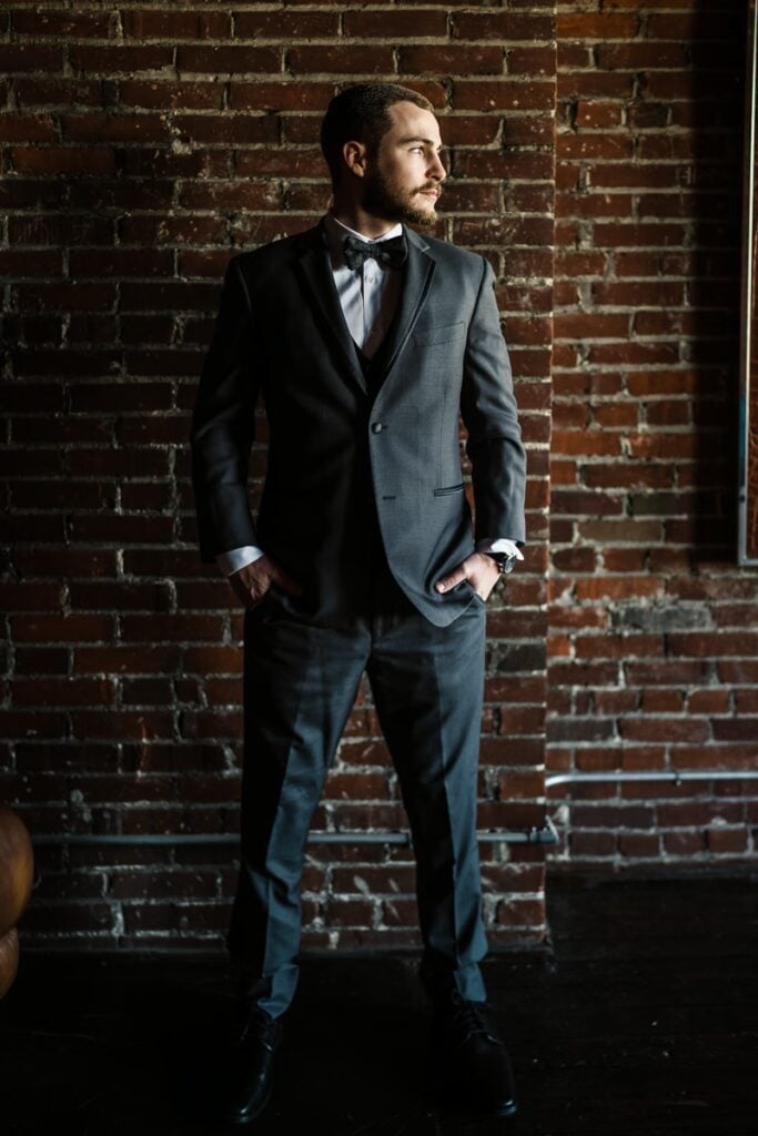 Groom get ready with brick wall background Mckinley G Photography
